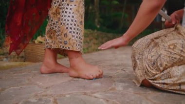 Taş zeminde bir kadının çıplak ayaklarının detaylı bir şekilde yakın plan çekimi. Bir el bir şeye uzanıp, doku ve iç etkileşime odaklanıyor..