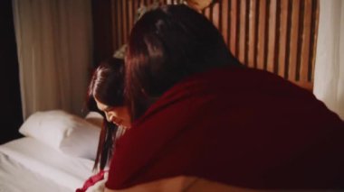 Yaşlı bir kadın yanında durup onu azarlarken ağlayan ve aşağı bakan genç bir kadının dokunaklı görüntüsü duygusal taciz ve üzüntüyü ön plana çıkarıyor..