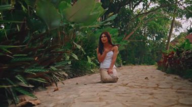 Mağlup olmuş bir kadının kayadan bahçe yolunda diz çökmüş, kaybolmuş ve kederli bakışları, kaçışına ya da yolculuğuna devam edememesi..