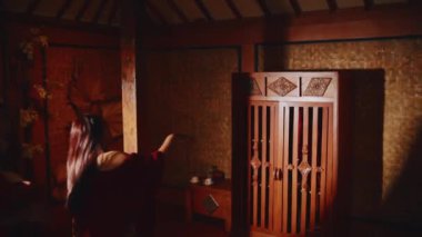 Geleneksel giyinen iki arkadaş bir tatil odasındaki ahşap dolaba gidip açıyorlar. Konaklamanın rahatlığı hakkında heyecanlı ve meraklı görünüyorlar..