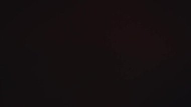 Uzun siyah saçlı, kırmızı sarong giyen, koyu bir gölgeye doğru yürüyen bir kadının arka görüntüsü. Atmosferik, gizemli ve dramatik görüntüler..