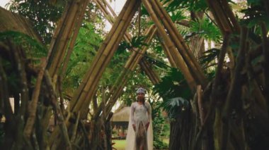 Tropikal bahçe yolu bambular tarafından çerçevelenmiş ve sabah saatlerinde bir insanla birlikte.