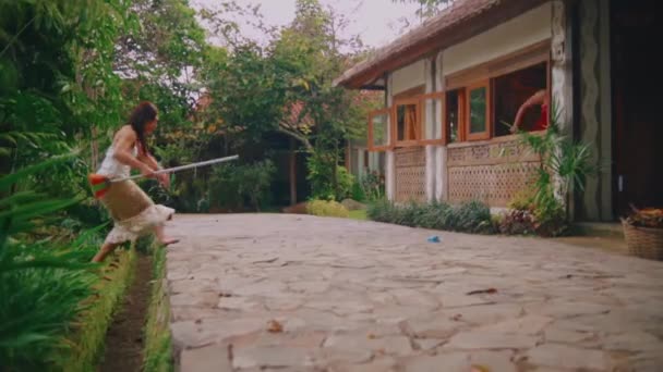 Woman Walking Watering Can Traditional House Lush Greenery Morning — стоковое видео