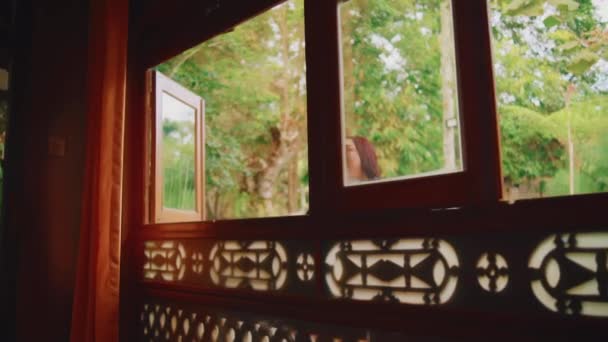Cheerful Woman Laughing Window Ornate Wooden Patterns Warm Indoor Lighting — วีดีโอสต็อก