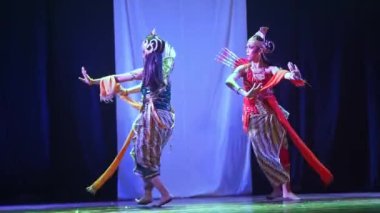 Geleneksel Endonezya kıyafetli iki dansçı sahnede dans ediyorlar..
