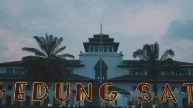 Merkezi kuleye sahip ve palmiye ağaçlarıyla çevrili eşsiz bir mimari tasarımı olan tarihi bir bina. Bina, GEDUNG SATE diye hecelenen neon ışıklarıyla aydınlandı..