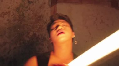 Loş ışıklı bir odada dokulu bir duvarı olan bir insanın bulanık görüntüsü..