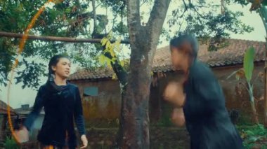 Arka planda eski binalarla kırsal bir alanda oynayan ve gülen iki kadın..