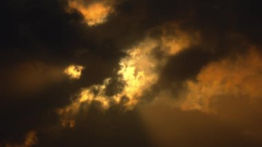 Karamsar gökyüzü, altın güneş ışığıyla aydınlatılan, karamsar ve atmosferik bir manzara yaratıyor..