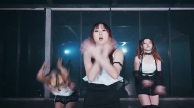 Yedi dansçıdan oluşan bir grup modern bir stüdyoda koreografili bir gösteri yapıyor. Şık kıyafetler giyiyorlar, kollarını kaldırıp senkronize adımlarla enerjik hareketler sergiliyorlar.. 