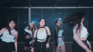 Beş dansçıdan oluşan bir grup loş bir stüdyoda senkronize dans gösterisi yapıyor. Şık kıyafetler giyiyorlar, siyah beyaz renklerin karışımını sergiliyorlar, dinamik hareketler ve ifadelerle..