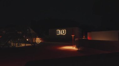 'BLU' harflerinin aydınlatıldığı modern bir çatı katı manzarası. Ortam sıcacık ve şık bir tasarım..