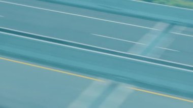 Otoyolda hız yapan, hareket ve hız gösteren bulanık bir araba görüntüsü. Yol temiz şeritlerle bomboş, aracın hızlı hareketini vurguluyor..