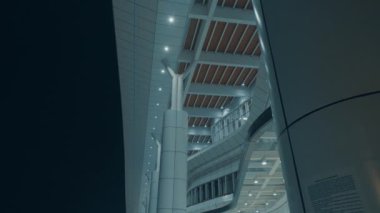 Geceleri modern bir mimari yapı, parlak çizgiler ve aydınlatılmış özellikler sergiliyor. Görüntü, binanın yapımında kullanılan eşsiz tasarım elementlerini ve malzemelerini yakalıyor..