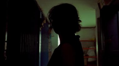 İpi düğümle tutan bir kişi, dokulu bir arka planın önünde duruyor. Odaklanma, ipi tutan elde. Gerginlik ya da hazırlık hissi uyandırıyor.. 