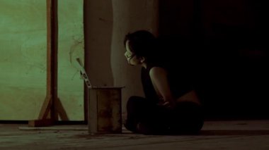 İpi düğümle tutan bir kişi, dokulu bir arka planın önünde duruyor. Odaklanma, ipi tutan elde. Gerginlik ya da hazırlık hissi uyandırıyor.. 