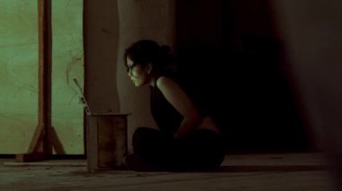 İpi düğümle tutan bir kişi, dokulu bir arka planın önünde duruyor. Odaklanma, ipi tutan elde. Gerginlik ya da hazırlık hissi uyandırıyor.. 