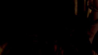 Terk edilmiş bir binada loş bir sahne, iki gölge figürün yer aldığı. Bir figür üzerinde bir çanta veya nesne asılı bir halat tutarken, diğer figür yakınlarda duruyor. Atmosfer gergin ve gizemli. 