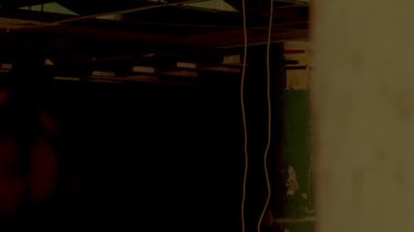 İki bireyin yakın ve samimi olduğu dramatik bir sahne. Bir kişi diğerine doğru eğiliyor, duvara yaslanıyor, gerilim ya da duyguyu çağrıştırıyor. Işıklar loş, karamsar bir atmosfer yaratıyor..