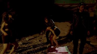 Loş ve terk edilmiş bir alanda duran bir grup insanın siluetleri. Atmosfer gölgelerle ve manzarayı aydınlatan bir ışık demeti ile ürkütücü. Rakamlar gizemli ve konumlandırılmış görünüyor. 