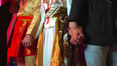 Renkli ışıklandırma ve bulanık efektlerle sırada el ele tutuşan bir grup insan..