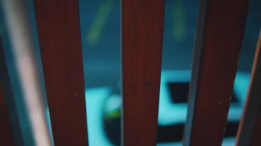 Modern bir açık hava barında ya da restoranda canlı bir gece sahnesi. Renkli neon ışıklar uzayı aydınlatarak canlı bir atmosfer yaratıyor. Bir grup insan masalara oturmuş, içki ve sohbetin tadını çıkarıyor, şehrin ışıklarıyla. 