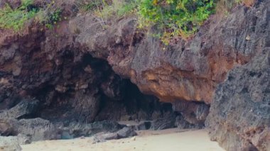Kayalık bir sahil sahnesinde mağara benzeri şekiller, desenli kayalar ve kumlu zemin vardı. Zirvede verimli yeşillik görülebilir, engebeli taşla çelişiyor. Atmosfer sakin ve doğal. Kıyı manzarası için ideal..