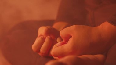 Tahta bir masada oturan ve yanında bir sandalye olan bir kişinin dramatik bir sahnesi. Atmosfer dumanla ve loş ışıkla güçlenir ve tiyatral bir etki yaratır.. 