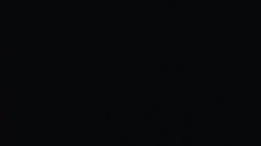 Karanlık bir tünelde, beyaz çizgili siyah bir elbise giyen, sürünerek ilerleyen genç bir çocuk. Yüzü koyu makyajla boyanmış ve yüzünde ciddi bir ifade var..