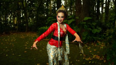 Endonezya kültürünün güzelliğini ve zenginliğini yansıtan kırmızı bir kostüm giyen geleneksel bir Sundanlı dansçı.