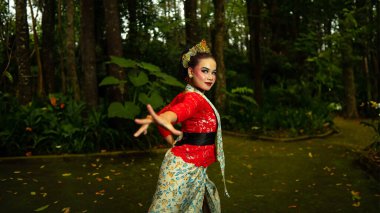 Endonezya kültürünün güzelliğini ve zenginliğini yansıtan kırmızı bir kostüm giyen geleneksel bir Sundanlı dansçı.