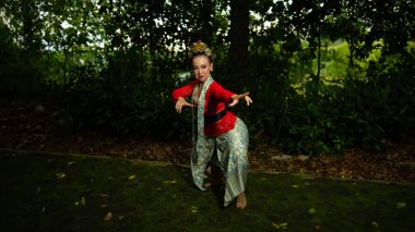 Geleneksel bir Endonezyalı dansçı, sabah ormandaki geleneksel bir tören ve kültür festivalinde gösteri yapıyor.