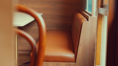 Kahverengi deri koltuklu ahşap bir standın olduğu rahat bir kafe. Ortam sıcak ve davetkar, rahatlama ve gelişigüzel buluşmalar için mükemmel..