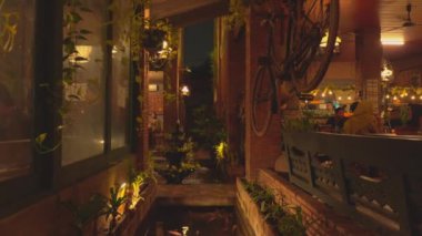 Tuğla duvarları, bitkileri ve su özellikleri olan samimi bir kafeterya. Bisikletler tavandan sarkıyor ve eşsiz bir ortam yaratıyor. Yumuşak ışıklandırma davetkar atmosferi güçlendirir. Müşteriler zamanlarının tadını çıkarırlar..