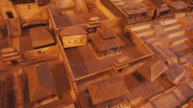 Çeşitli binalar, sokaklar ve mimari özelliklerin sergilendiği antik şehir planının ayrıntılı bir modeli. Yapıların geleneksel çatıları var ve tarihi kentsel planlamayı yansıtan bir şebeke şeklinde düzenlenmiş..