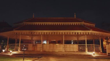 Geleneksel silah ve eserlerin sergilendiği bir müzenin iç görünüşü. Odada çeşitli alet ve silahlarla dolu cam vitrinlerin yanı sıra ahşap heykeller bulunuyor..