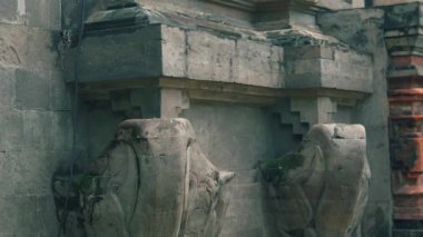 Karmaşık oymalar ve yıpranmış yüzeyler içeren antik taş mimarisinin yakın çekimi, tarihi işçilik ve dokuların sergilenmesi.