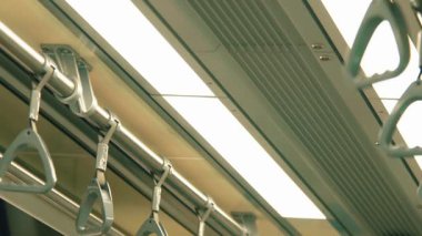 Tepe ışıkları ve tırabzanları gösteren bir metro treni manzarası. Görüntü, toplu taşımanın modern tasarımı ve işlevselliğini yansıtıyor..