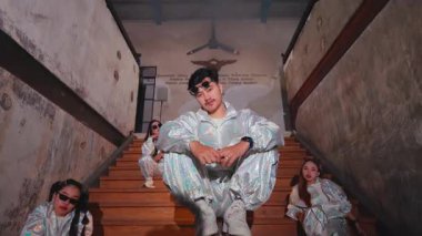 Tepesinde yansıtıcı giysilerle çevrili loş ışıklı bir merdiven. Atmosfer ürkütücü ve gizemli. Gölgeler dramatik bir etki yaratıyor..