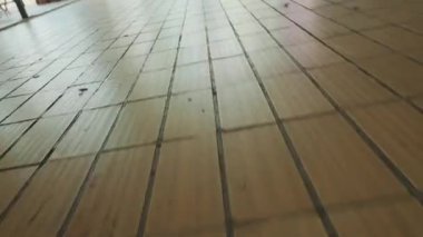 Parlak bir ceket, renkli bir gömlek ve güneş gözlüğü giyen şık genç bir adam arka planda neon bir tabelayla kapının önünde duruyor. Ortam canlı, şehirli havası var..