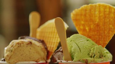 Çikolata ve nane aromalı, üzerinde waffle külahları ve tahta kaşıklar olan lezzetli dondurmalar çok cazip bir tatlı gösterisi yaratıyor..