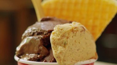 İki çeşnili lezzetli bir dondurma bardağının yakın çekimi: zengin çikolata ve fındıklı kremalı vanilya, üstüne de waffle külahı..