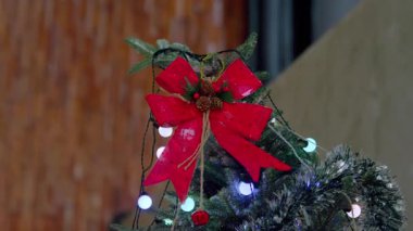 Kırmızı bir fiyonk, kozalak ve beyaz ışıklarla süslenmiş bir Noel ağacının yakın çekimi..