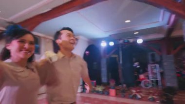 Bir grup dansçı damalı zemini olan geniş bir salonda gösteri yapıyorlar. Diğerleri gündelik giysiler giyerken, merkez dansçı bir taç ve dalgalı bir etek giyer. Ayarda zarif dekor ve sıcak ışıklandırma yer alıyor.