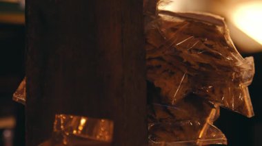 Loş bir ortamda ahşap bir direğe asılı duran paket aperatifler, rahat bir atmosfer sergiliyor..