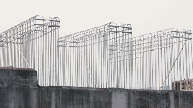 Beton bir yapıdan çıkan metalin yakın çekim demiri parlak bir gökyüzüne karşı eşsiz bir mimari model oluşturuyor..
