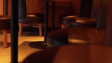 Küçük bir masanın etrafına dizilmiş koyu deri koltukların olduğu rahat bir iç mekan, rahat bir atmosfer yaratıyor..