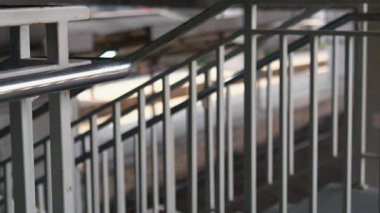 Bulanık bir arka planı olan metal korkulukların yakın çekim görüntüsü merdivenlerin tasarımı ve yapısını gözler önüne seriyor..