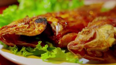 Taze marul yatağında servis edilen ızgara balıklar, çıtır çıtır cilt ve canlı renkler, yemek fotoğrafçılığı için ideal..