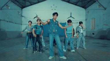 Kot giymiş şık genç bir grup endüstriyel bir ortamda gece boyunca serin mavi ışıklandırmayla poz veriyor.